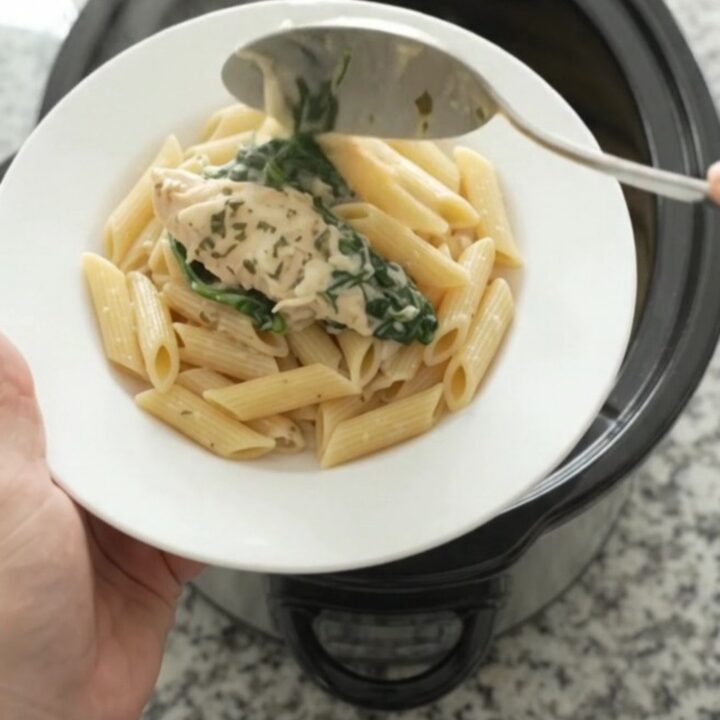 Creamy crockpot chicken tenders with spinach and artichokes, topped with melted mozzarella and garlic butter.