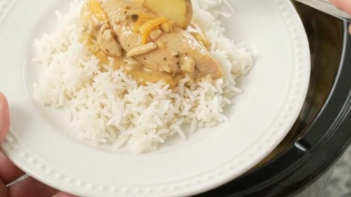 Slow cooker with golden cheddar chicken and potatoes, ready to serve