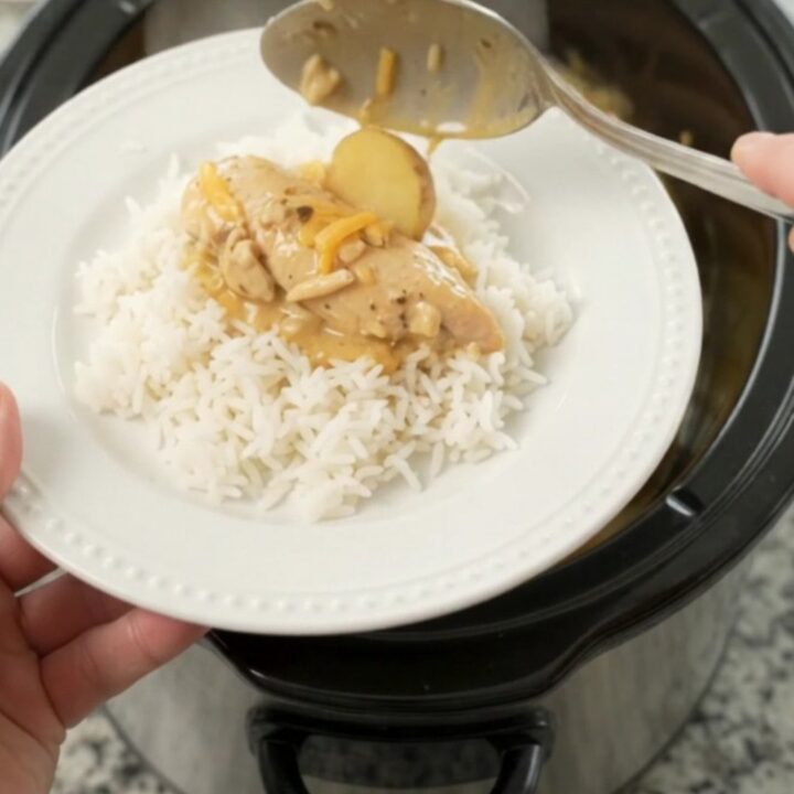 Slow cooker with golden cheddar chicken and potatoes, ready to serve