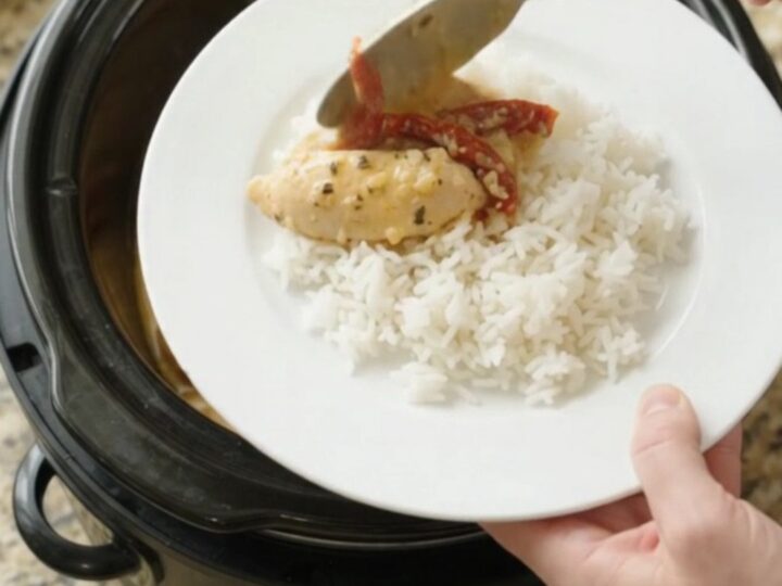 Slow cooker chicken tenders in golden cheddar sauce with sun-dried tomatoes, served over rice