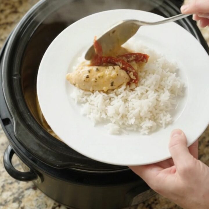 Slow cooker chicken tenders in golden cheddar sauce with sun-dried tomatoes, served over rice