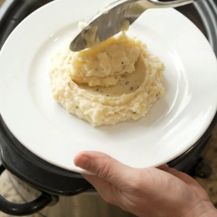 Creamy Swiss and sun-dried tomato chicken tenders in a slow cooker, with melted cheese and tomato ribbons visible.
