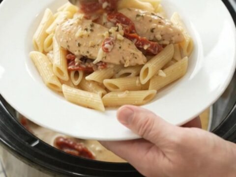 Slow cooker chicken tenders in creamy mozzarella sauce with sun-dried tomatoes, in a black crockpot