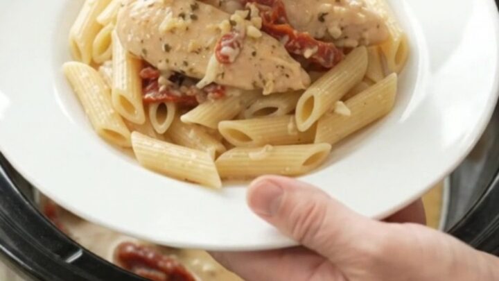 Slow cooker chicken tenders in creamy mozzarella sauce with sun-dried tomatoes, in a black crockpot