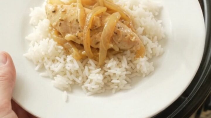 Golden cheddar French onion chicken tenders bubbling in a slow cooker with melted cheese and caramelized onions