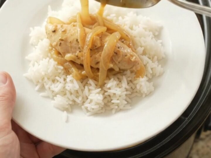 Golden cheddar French onion chicken tenders bubbling in a slow cooker with melted cheese and caramelized onions
