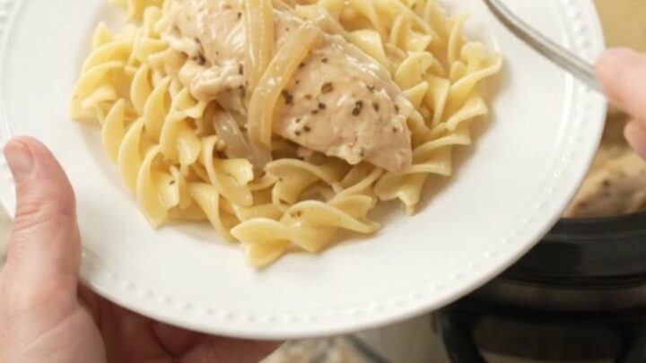 Slow cooker chicken tenders in a creamy Parmesan and onion gravy, topped with caramelized onions.
