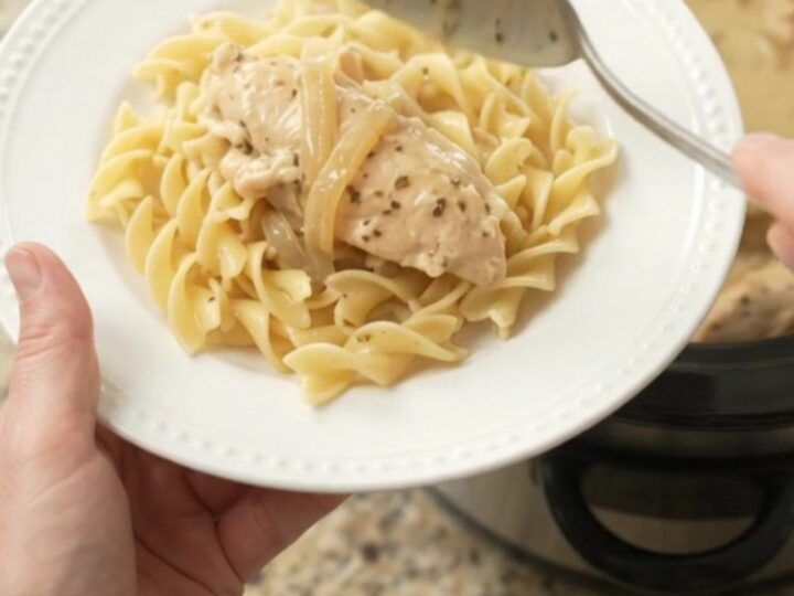 Slow cooker chicken tenders in a creamy Parmesan and onion gravy, topped with caramelized onions.