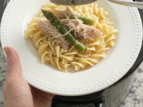 Slow cooker filled with creamy turkey and asparagus in a rich Parmesan sauce