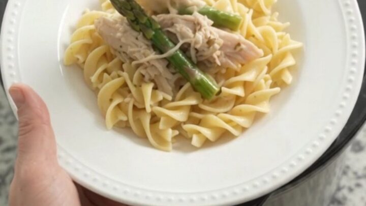 Slow cooker filled with creamy turkey and asparagus in a rich Parmesan sauce