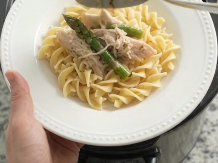 Slow cooker filled with creamy turkey and asparagus in a rich Parmesan sauce