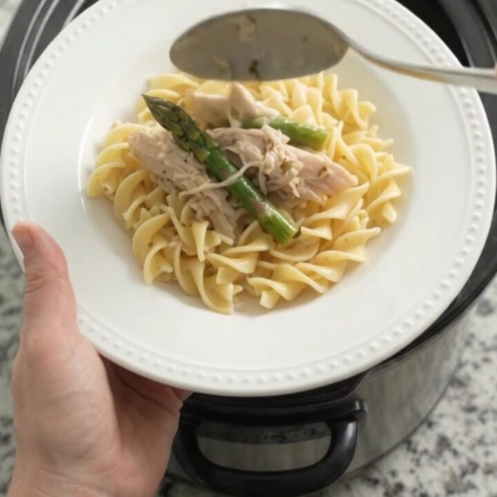 Slow cooker filled with creamy turkey and asparagus in a rich Parmesan sauce