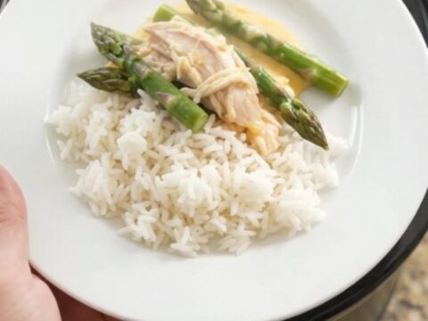 Slow cooker filled with creamy turkey, asparagus, and melted cheddar cheese