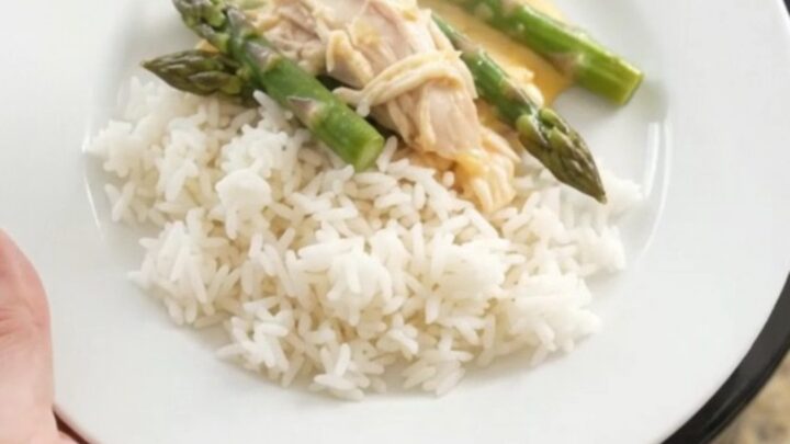 Slow cooker filled with creamy turkey, asparagus, and melted cheddar cheese
