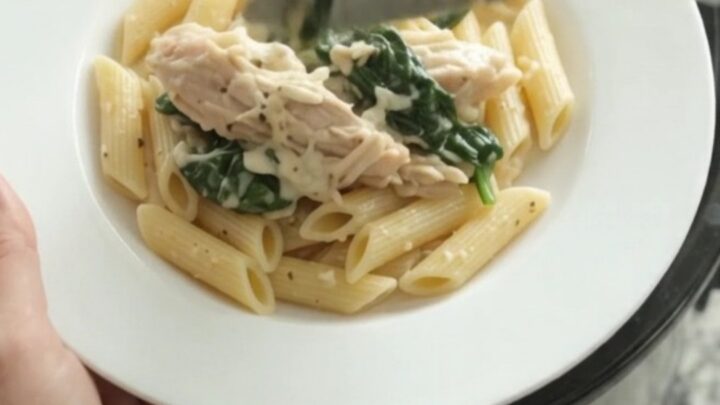 Slow cooker filled with creamy turkey, spinach, and artichokes in mozzarella sauce
