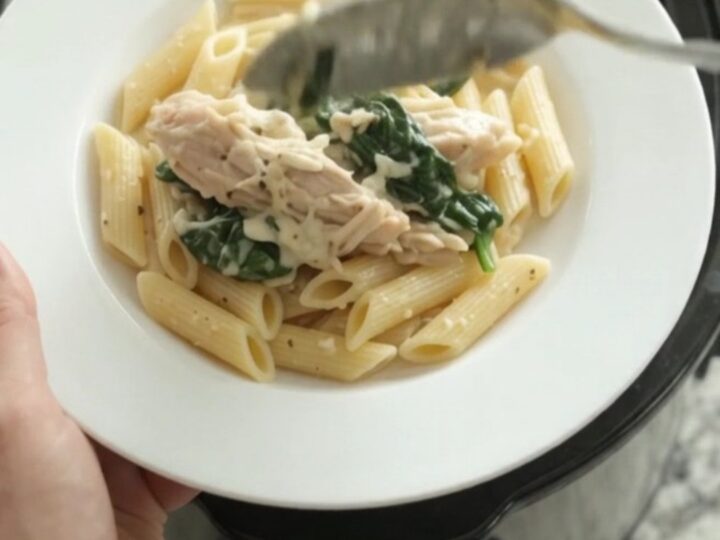 Slow cooker filled with creamy turkey, spinach, and artichokes in mozzarella sauce