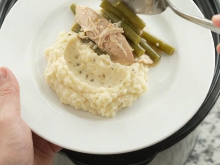 Slow cooker creamy Swiss green bean turkey breast in a black Crockpot, bubbling and steamy