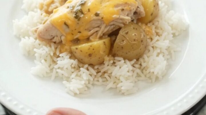 Creamy slow cooker turkey and potatoes with melted cheddar in a black crock