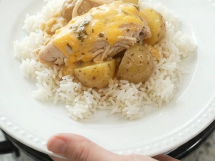 Creamy slow cooker turkey and potatoes with melted cheddar in a black crock