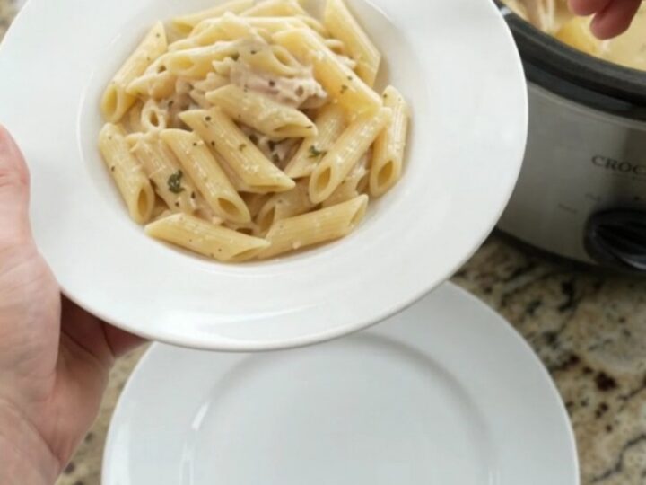 Slow cooker turkey breast with baby potatoes and melted mozzarella, creamy sauce bubbling in a black crockpot