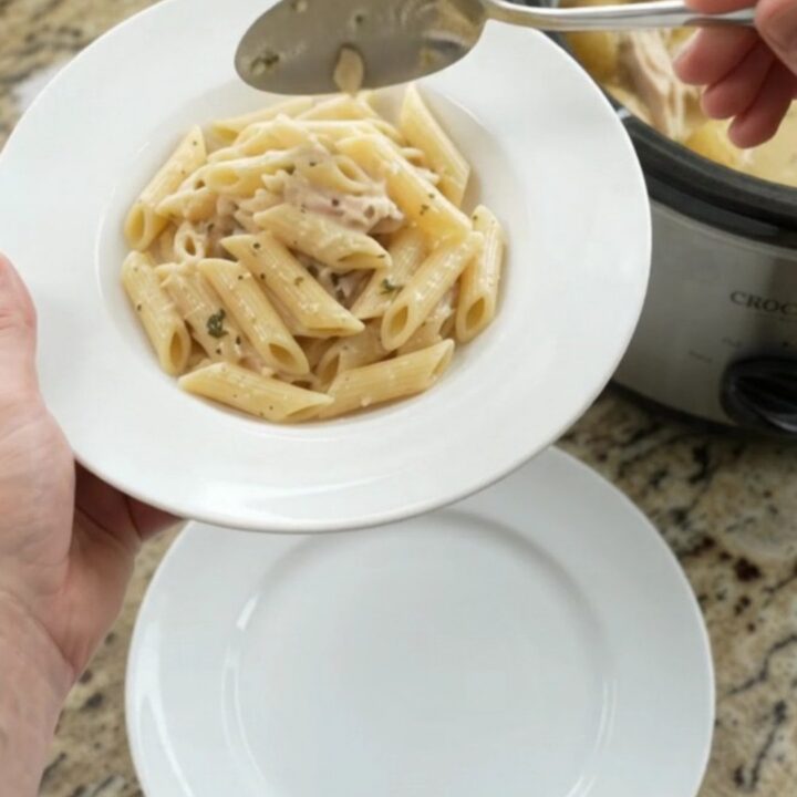 Slow cooker turkey breast with baby potatoes and melted mozzarella, creamy sauce bubbling in a black crockpot