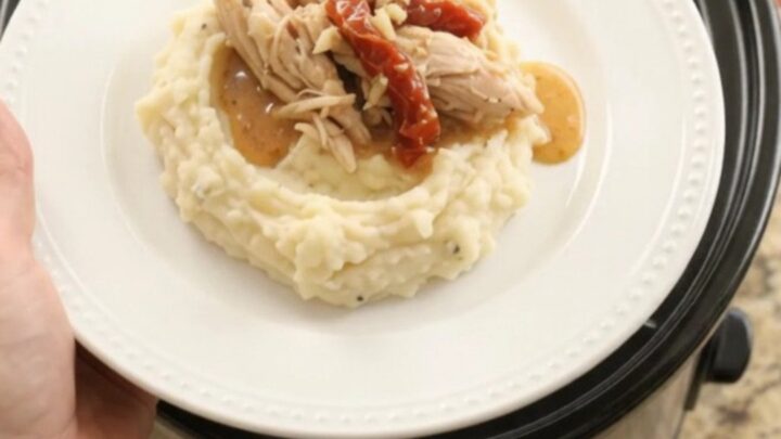 Creamy slow cooker turkey breast with sun-dried tomatoes and Swiss cheese sauce in a black crockpot