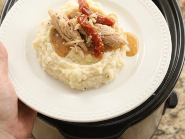 Creamy slow cooker turkey breast with sun-dried tomatoes and Swiss cheese sauce in a black crockpot