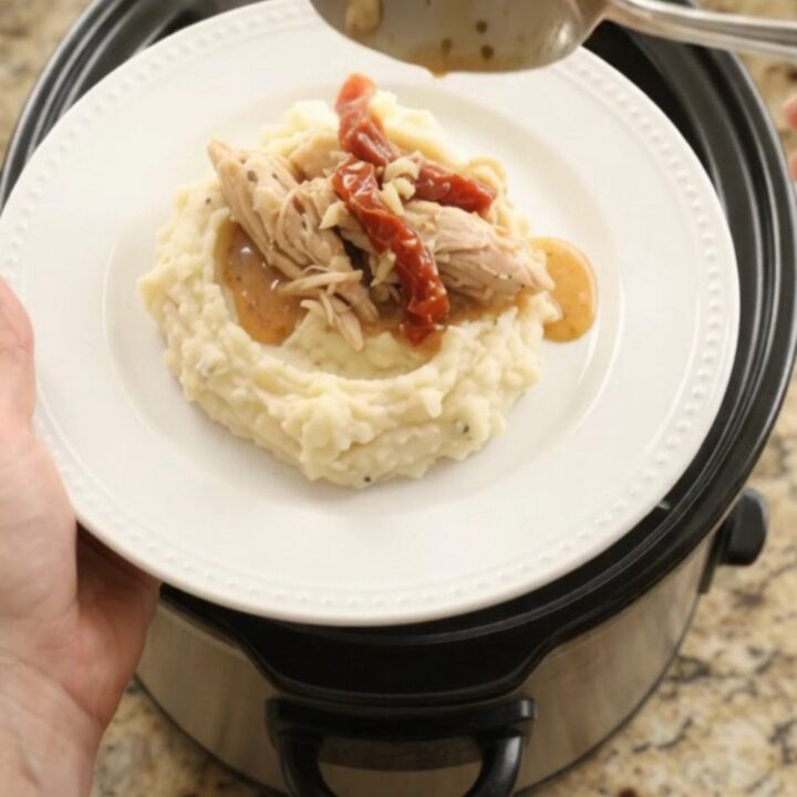 Creamy slow cooker turkey breast with sun-dried tomatoes and Swiss cheese sauce in a black crockpot