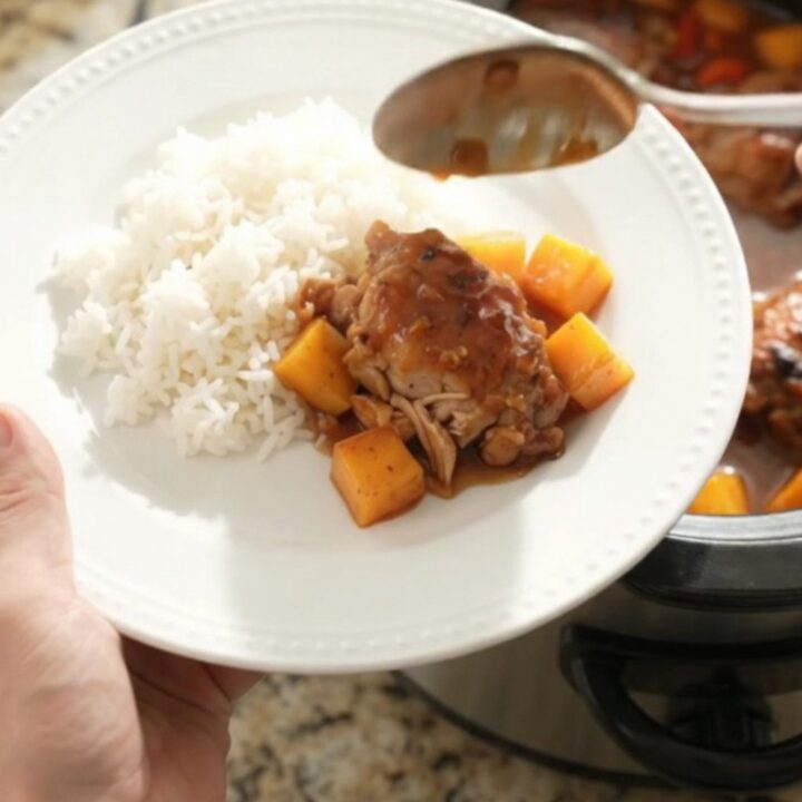 Slow cooker mango hickory BBQ chicken thighs with sauce and mango cubes