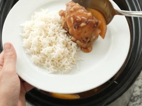 Slow-cooked chicken thighs glazed with honey-soy sauce and peaches in a black Crockpot