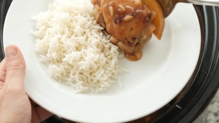 Slow-cooked chicken thighs glazed with honey-soy sauce and peaches in a black Crockpot