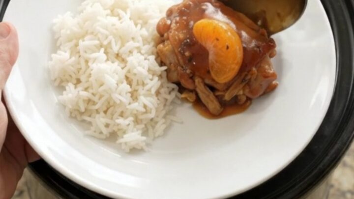 Slow-cooker chicken thighs in a glossy mandarin BBQ sauce, garnished with sesame seeds and green onions