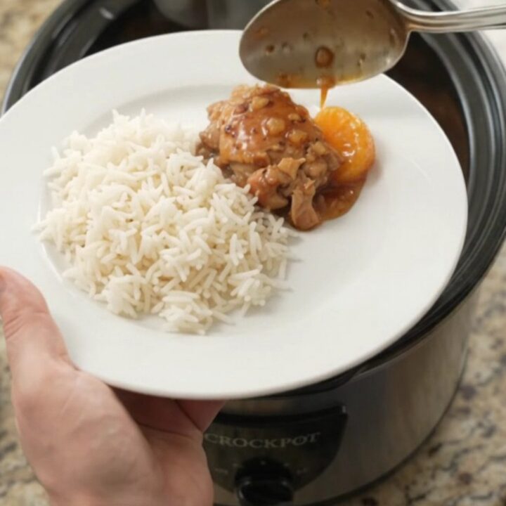 Mandarin honey soy chicken thighs in a slow cooker, glistening with sticky sauce