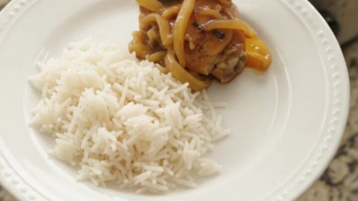 Caramelized pull-apart chicken thighs in a sticky apricot honey soy glaze, served in a black slow cooker.