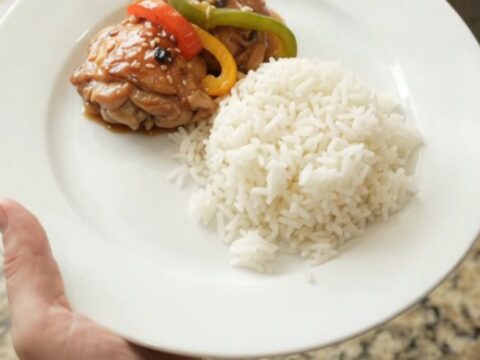 Slow cooker filled with teriyaki chicken thighs and bell peppers