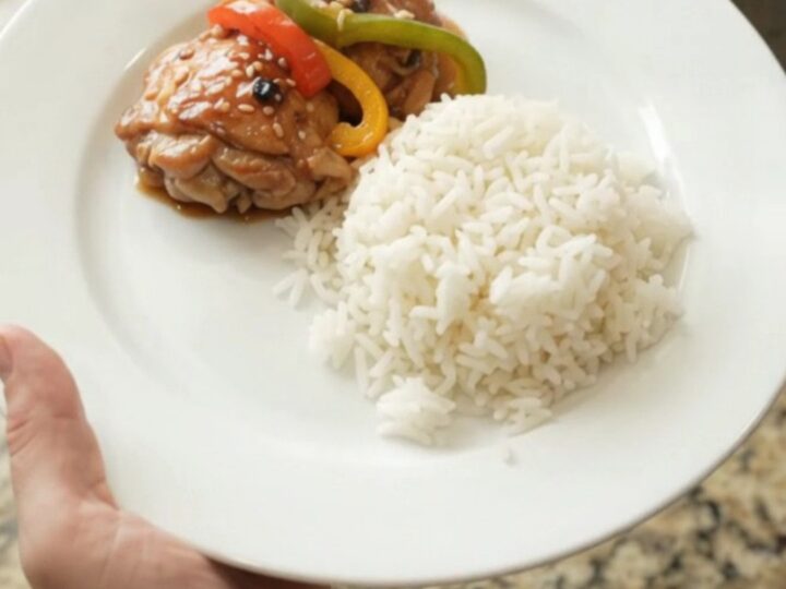 Slow cooker filled with teriyaki chicken thighs and bell peppers