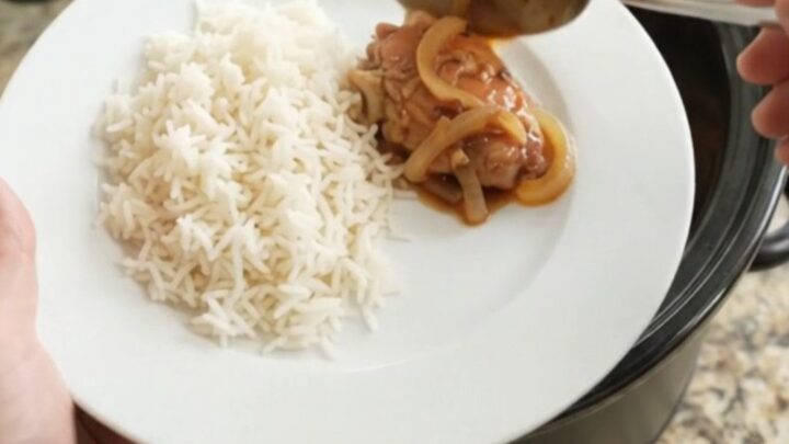 Slow cooker honey soy chicken thighs with caramelized onions in a black crock