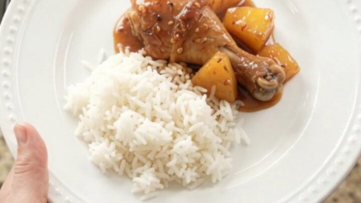 Glazed chicken drumsticks with pineapple in a slow cooker, topped with sesame seeds