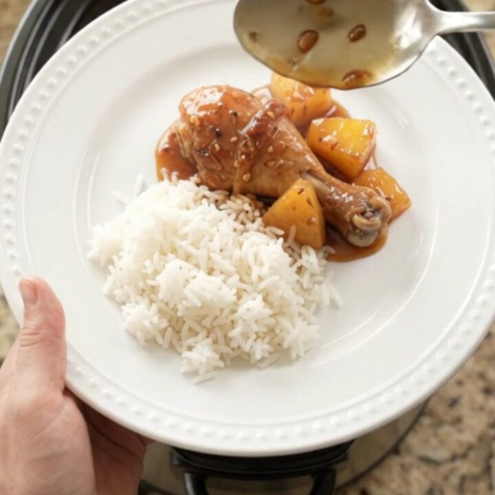 Glazed chicken drumsticks with pineapple in a slow cooker, topped with sesame seeds