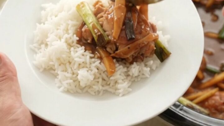 Pull-apart chicken thighs in glossy hickory BBQ sauce with ginger and scallions in a slow cooker