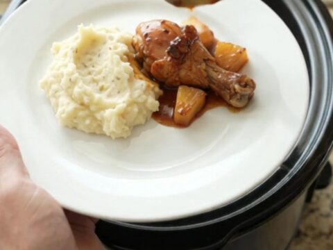 Glazed chicken drumsticks with caramelized pineapple in a slow cooker, glossy bourbon sauce