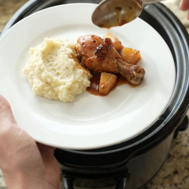 Glazed chicken drumsticks with caramelized pineapple in a slow cooker, glossy bourbon sauce