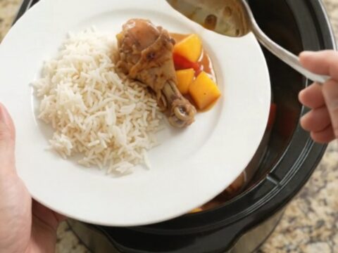 Glazed chicken drumsticks with mango and red pepper in a slow cooker