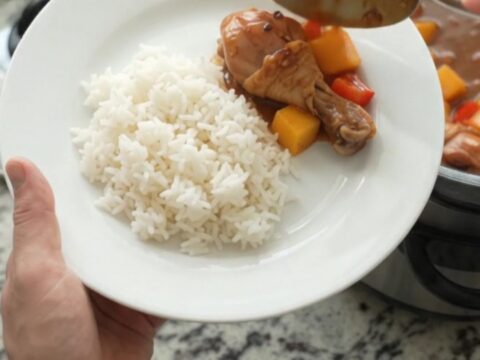 Slow-cooker mango teriyaki chicken drumsticks in a glossy glaze with mango and red peppers.