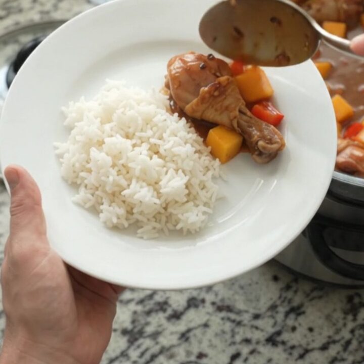 Slow-cooker mango teriyaki chicken drumsticks in a glossy glaze with mango and red peppers.