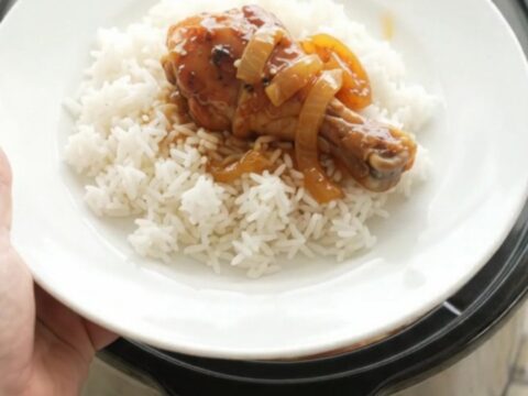 Glazed chicken drumsticks in a slow cooker with apricot teriyaki sauce and sesame seeds