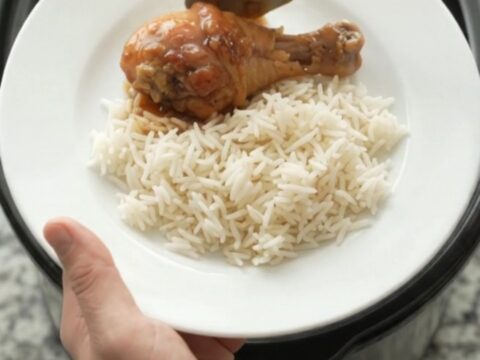Glazed chicken drumsticks in a slow cooker with garlic and scallions, sticky honey soy sauce bubbling