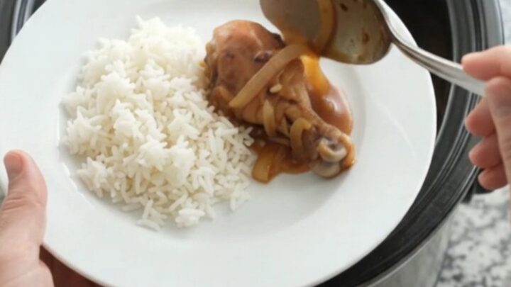 Glazed chicken drumsticks in a slow cooker with caramelized onions and sesame seeds