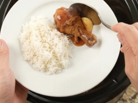 Glazed chicken drumsticks in a slow cooker with garlic and scallions