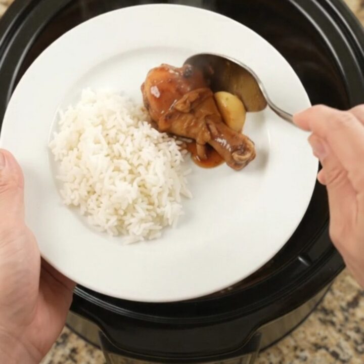 Glazed chicken drumsticks in a slow cooker with garlic and scallions
